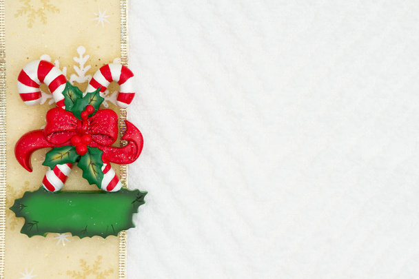 Рождественские конфеты трости с луком с золотой лентой снежинки на белом фоне шеврона текстурированной ткани, которые вы можете использовать в качестве макета для вашего сообщения на Рождество
 - Фото, изображение