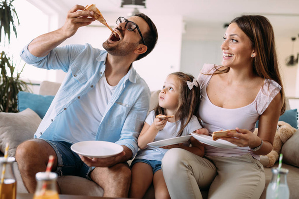Portrait of happy family sharing pizza together at home - Foto, Bild
