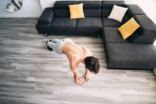 дорослий чоловік тренування грудей м'язи вдома роблячи Push-Ups
 - Фото, зображення