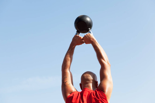 Exercising with a kettlebell. Fitness training outdoors. - Foto, Imagen