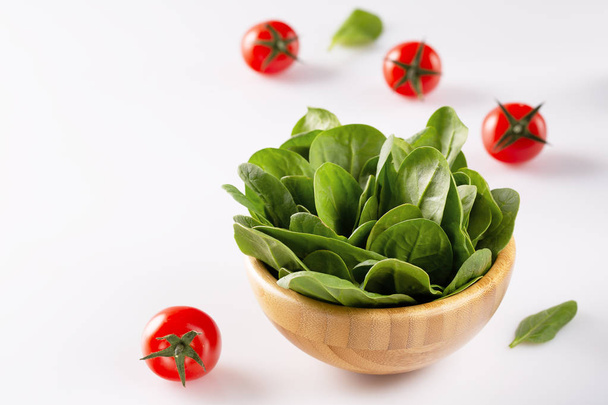 Fresh spinach leaves in wooden bowl. Healthy food with copy space. Detox. Summer time. Selective focus. - Photo, Image