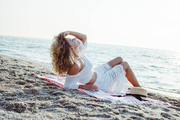 Beautiful young woman relaxing on the beach - Fotoğraf, Görsel