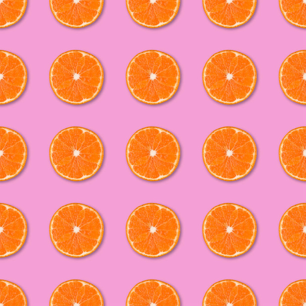 新鮮なオレンジ タンジェリンは、シームレスなパターンをスライスします。ピンクの背景に柑橘系の果物のクローズ アップ。スタジオ撮影. - 写真・画像