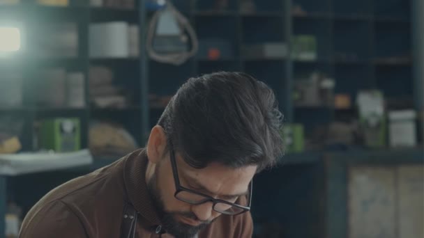 Portrait of a brunet man with glasses, a beard and a working apron - Кадри, відео