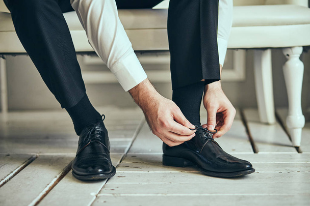 обувь бизнесмена, готовящийся к работе мужчина, утро жениха перед свадебной церемонией. Мужская мода - Фото, изображение