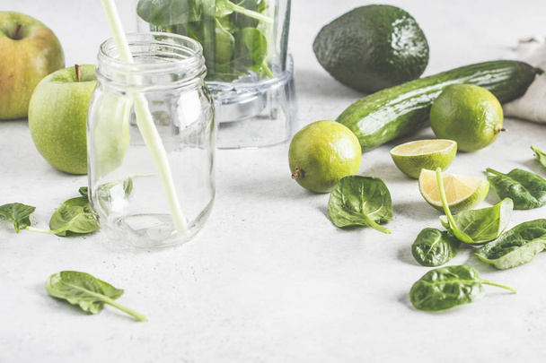 Preparation of green smoothie on the white table. Healthy plant based food concept. - Foto, afbeelding