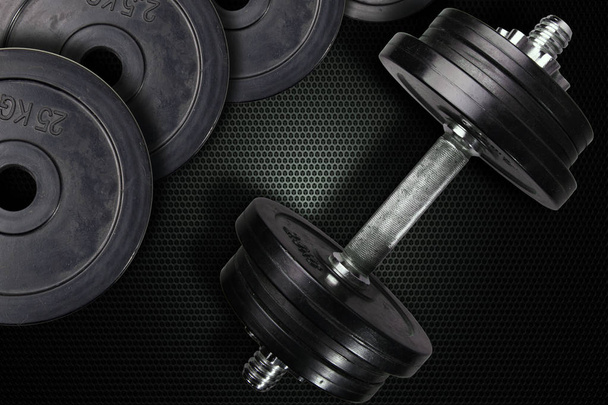 Dumbells and weights on a carbon background. - Photo, Image