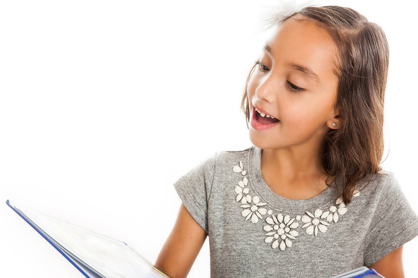 Mooie gelukkig klein meisje het lezen van een boek geïsoleerd op witte achtergrond - Foto, afbeelding