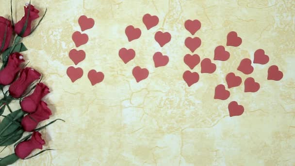 main de l'homme met un coeur en tissu doux près des roses rouges et l'amour de l'inscription
 - Séquence, vidéo