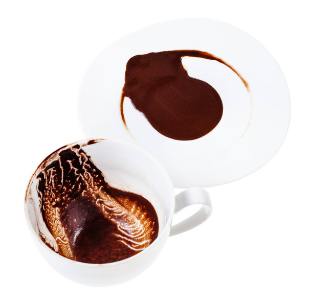 divination on carob drink sediments - white porcelain cup and saucer with carob grounds isolated on white background - Фото, изображение