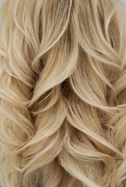 Trendy kapsel met weave blonde krullen. Close-up - Foto, afbeelding