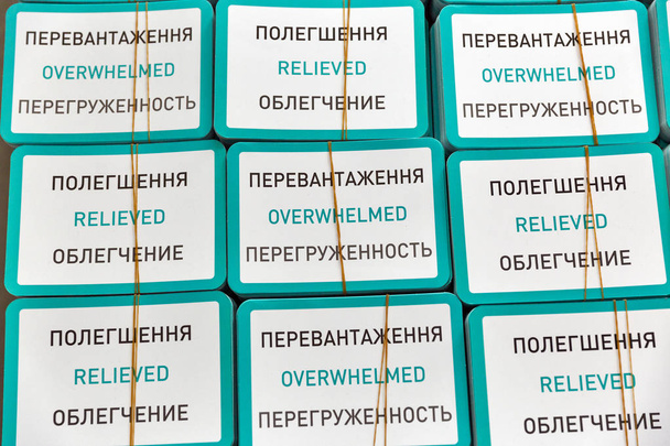 piles de cartes portant des inscriptions : accablé et relevée en ukrainien, anglais et russe, closeup - Photo, image