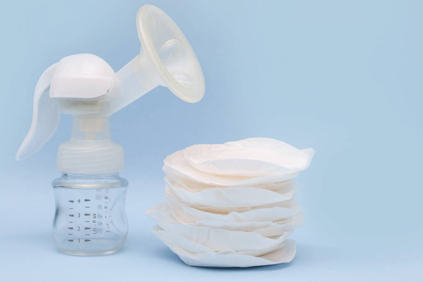 Manual breast pump with breast pads on the blue background - Foto, imagen