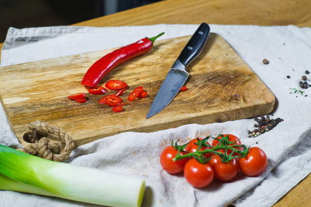 Chili peppers op een houten snijplank. Achtergrond keuken, zijaanzicht - Foto, afbeelding