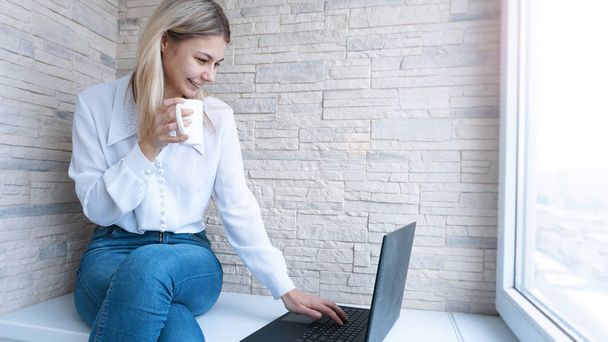 Side view. Young business woman with a cup of coffee and notebook. - Foto, Imagen