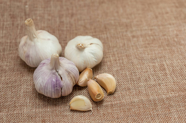 the garlic heads on a brown fabric - Foto, Imagen
