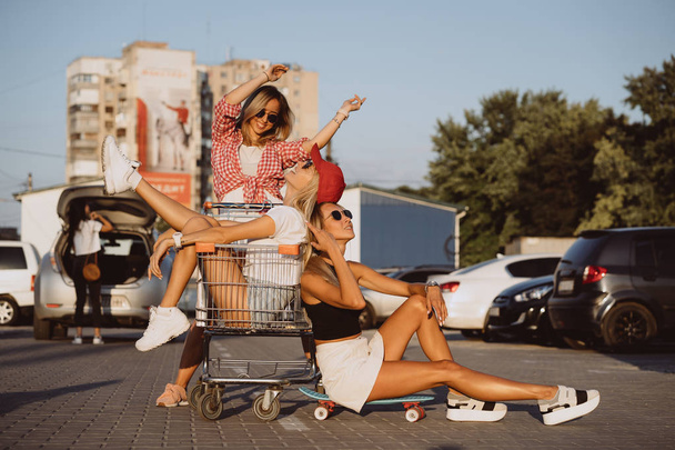 Les jeunes femmes avec un chariot de supermarché s'amusent
 - Photo, image