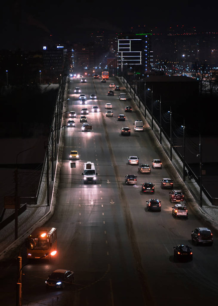 Smug światła samochodu na autostradzie w nocy nowoczesnego miasta - Zdjęcie, obraz
