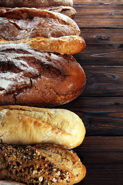 Assortiment de pains cuits au four et rouleaux de pain sur fond de table en bois. Concept affiche boulangerie
 - Photo, image
