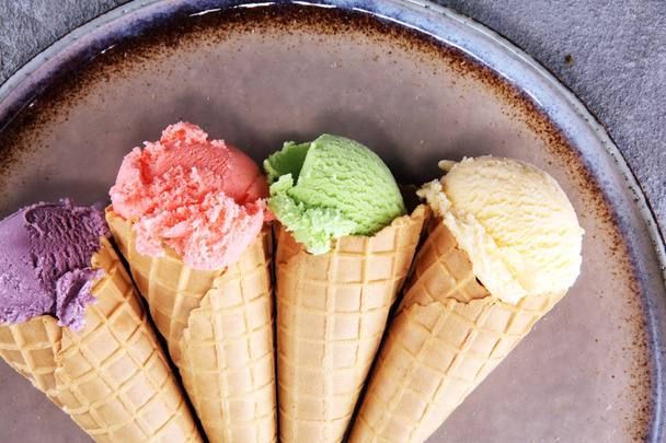 Conjunto de colheres de sorvete de diferentes cores e sabores com bagas, nozes e frutas e baunilha
  - Foto, Imagem