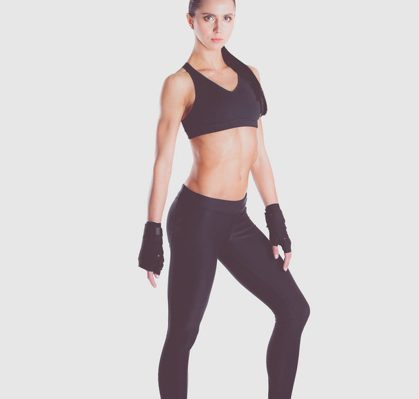 Muscular young woman posing in sportswear against white background. - Φωτογραφία, εικόνα