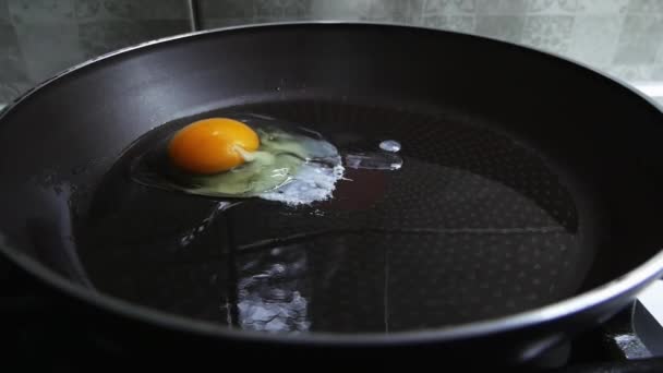 Eggs dropped on hot pan in slow motion, cooking breakfast - Кадры, видео
