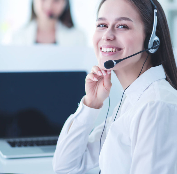 Smiling businesswoman or helpline operator with headset and computer at office - Фото, изображение