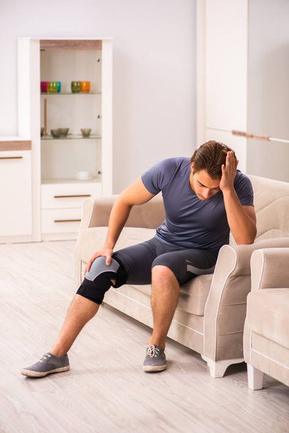 Молодой человек с травмой колена выздоравливает дома
 - Фото, изображение