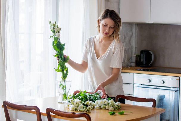 girl ipreparing a bouquet of white roses before putting them in a vase - Photo, Image