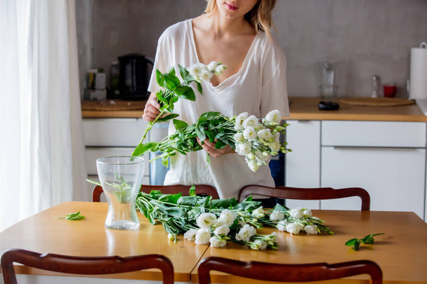 chica ipreparing un ramo de rosas blancas antes de ponerlos en un jarrón
 - Foto, imagen