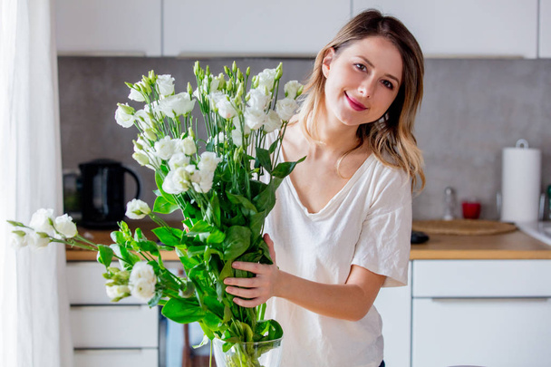 ipreparing κορίτσι ένα μπουκέτο από λευκά τριαντάφυλλα πριν τα βάλετε σε ένα βάζο - Φωτογραφία, εικόνα