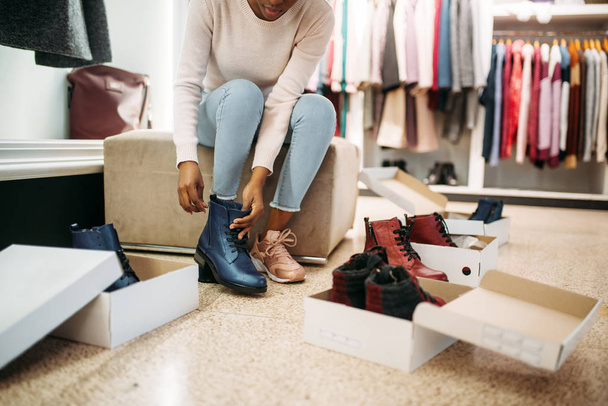Mulher negra a experimentar sapatos, a fazer compras. Shopaholic na loja de roupas, estilo de vida de consumismo, moda
 - Foto, Imagem