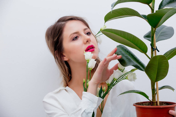 Beautiful woman with white roses in sleeves with plant - Фото, зображення