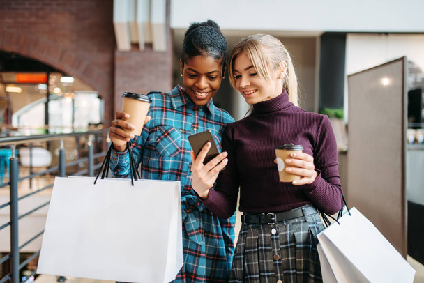 Kaksi tyttöystävää tekee selfien kaupassa, ostoksilla. Ostoskeskukset vaatekaupassa, kulutustottumukset, muoti
 - Valokuva, kuva