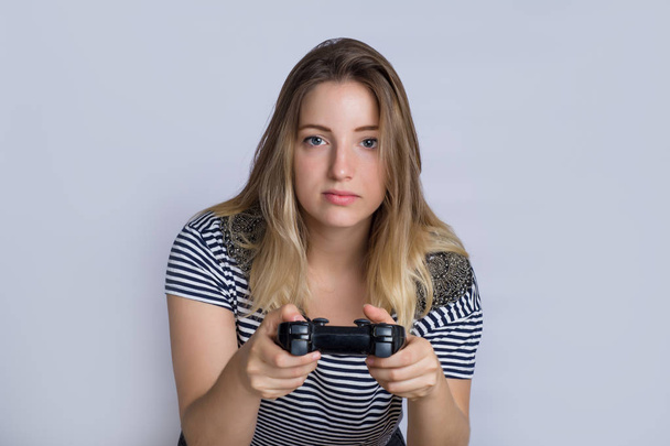 Portrait of young beautiful woman playing video games in studio. - Foto, imagen