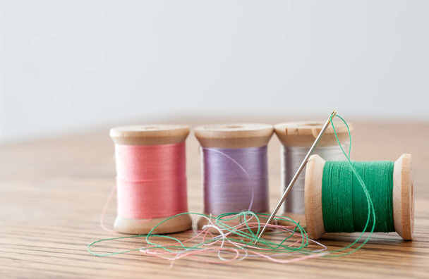Veelkleurige spoelen van wol met schroefdraad naald - Foto, afbeelding