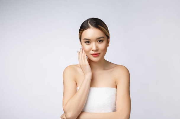 Retrato de bela mulher asiática maquiagem de cosméticos, menina mão toque bochecha, rosto de beleza perfeito com bem-estar isolado no fundo branco
 - Foto, Imagem