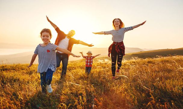 Boldog család: anya, apa, gyermekek fia és lánya, a természet sunse - Fotó, kép