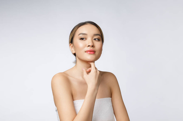 Muotokuva kaunis aasialainen nainen meikki kosmeettisia, tyttö käsi kosketa poski, kasvot kauneuden täydellinen hyvinvointi eristetty valkoisella taustalla - Valokuva, kuva