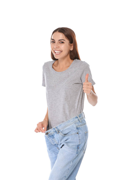 Slim woman in oversized jeans on white background. Weight loss - Foto, Bild