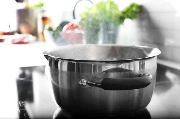 Pot with boiling water on electric stove in kitchen - Fotografie, Obrázek
