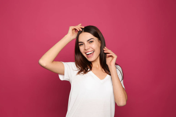 Portrait of young woman laughing on color background - Fotó, kép