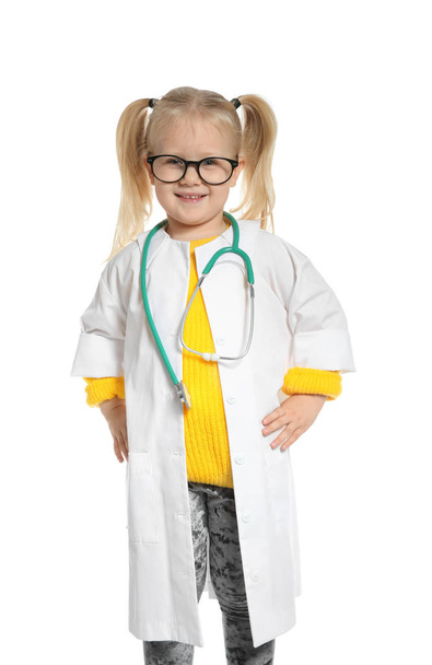 Cute child imagining herself as doctor while playing with reflex hammer and doll on color background - Photo, image