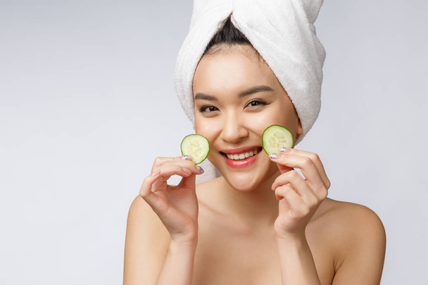 piękno młody Azji kobiety skóra pielęgnacja obraz z ogórek na biały tło studio. - Zdjęcie, obraz