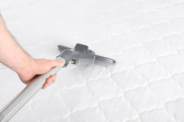 Man disinfecting mattress with vacuum cleaner, closeup. Space for text - Fotografie, Obrázek