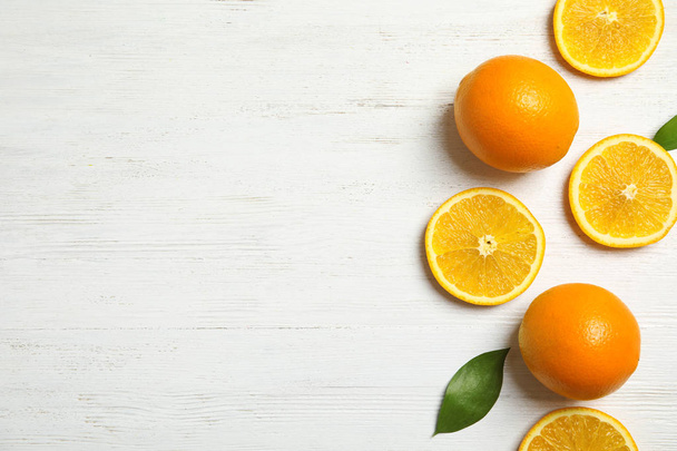 Flat lay composition with fresh oranges on wooden table. Space for text - Photo, image