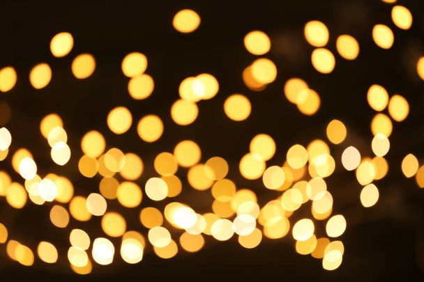 Beautiful golden lights on dark background. Bokeh effect - Foto, Bild
