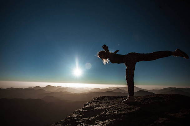 mooie jonge vrouw praktijken yoga op Mozes berg bij zonsopgang - Foto, afbeelding