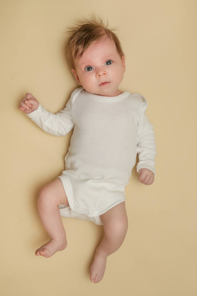 Adorable newborn portrait on the yellow background, studio shot - Фото, изображение