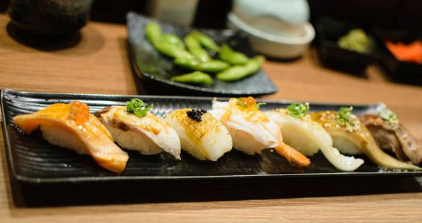 Sushi Artísticamente Se muestra de cerca en un plato de servir
 - Foto, Imagen